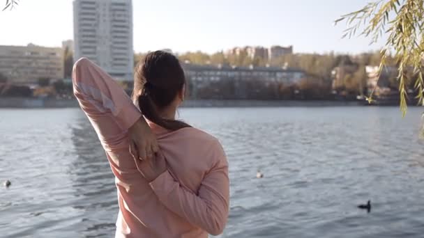 Menina fazendo ioga no parque em um fundo do rio — Vídeo de Stock