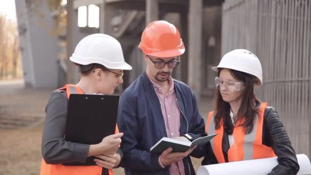 Dvě ženy a muž stavitelé jsou kontrola stavby — Stock video