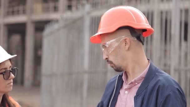 Duas mulheres e um homem construtores estão verificando a construção — Vídeo de Stock