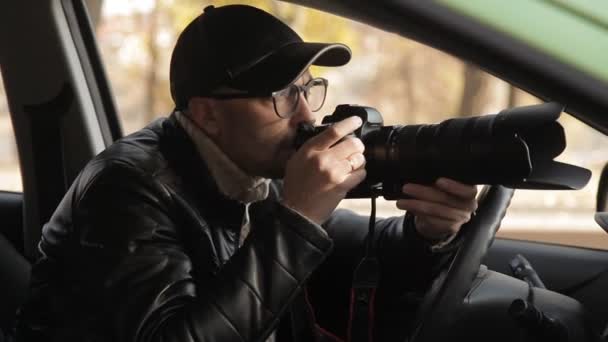 Soukromý detektiv nebo špion provádí ostrahu objektu dohledu. Muž tajně fotí z okna auta — Stock video