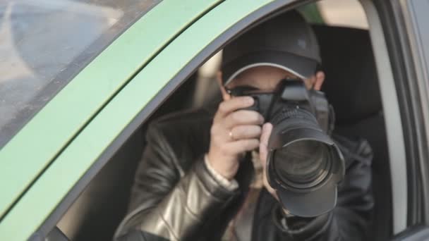 Un detective privado o un espía lleva a cabo la vigilancia del objeto de vigilancia. Un hombre tomando fotos en secreto desde la ventana del coche — Vídeos de Stock