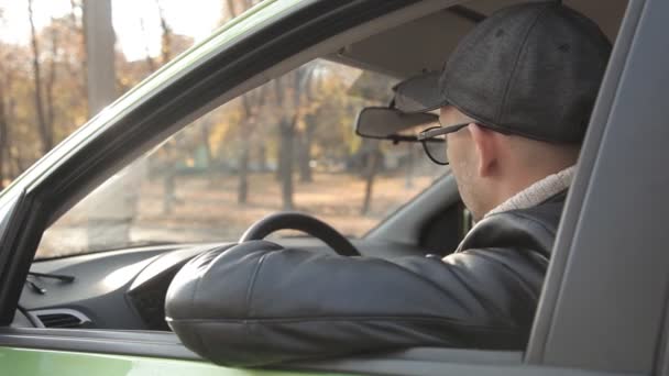 Um detetive particular ou um espião conduz a vigilância do objeto de vigilância. Um homem secretamente tirando fotos da janela do carro — Vídeo de Stock