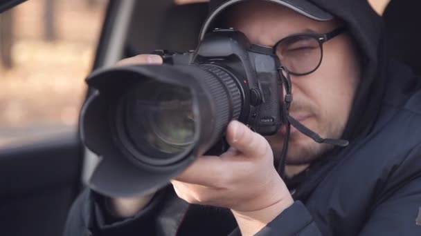 Ein Privatdetektiv oder Spion überwacht das Überwachungsobjekt. ein Mann macht heimlich Fotos aus dem Autofenster — Stockvideo
