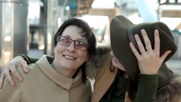 Mãe e filha adulta em óculos na estação ferroviária olhar para a câmera e sorrir para o retrato de vídeo — Vídeo de Stock