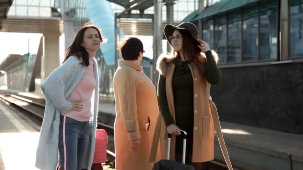 Három nő az utasok a vasútállomáson beszélni aggódni a késedelem a vonat — Stock videók