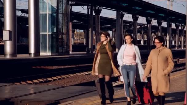 Passageiros com malas andando na plataforma da estação ferroviária. Três mulheres com malas andando na plataforma da estação ferroviária — Vídeo de Stock