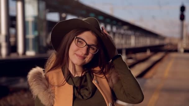 Jeune femme américaine portrait à l'extérieur. Belle femme naturelle avec des lunettes et un chapeau souriant et regardant la caméra — Video