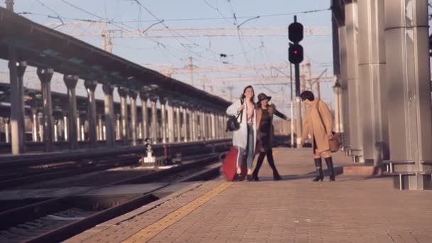 Cestující s kufry na platformě nádraží. Tři ženy s kufry na platformě železniční stanice — Stock video