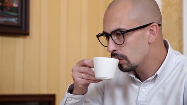 Negocios, personas y concepto de tecnología - hombre de negocios en gafas con computadora portátil beber café o té en la oficina — Vídeo de stock