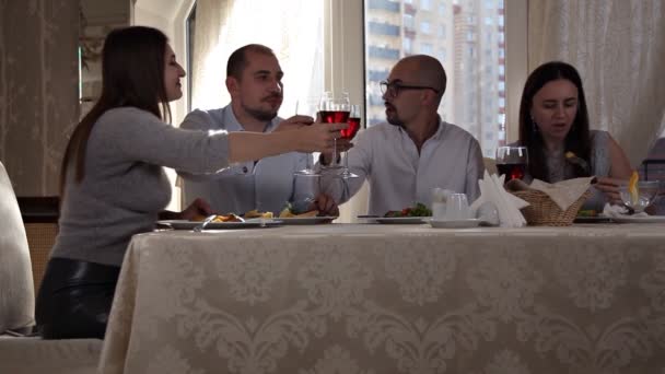 Група друзів насолоджується вечірньою їжею з вином в ресторані — стокове відео