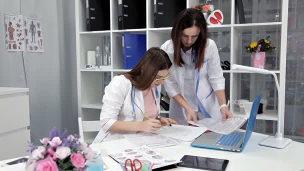 Doutor e seu assistente discutem paciente — Vídeo de Stock