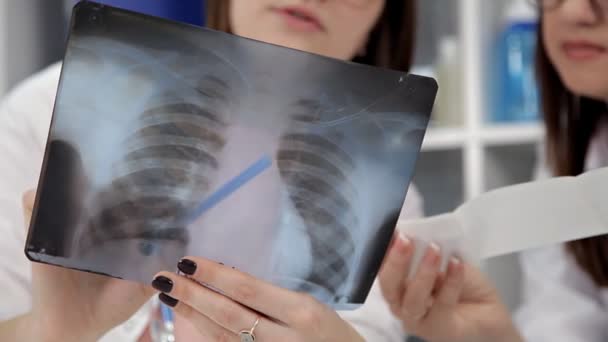 Δύο γυναίκες γιατροί βλέπουν ακτινογραφίες σε νοσοκομείο. — Αρχείο Βίντεο