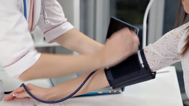Arts en patiënt bloeddruk check-up - vrouwelijke patiënt — Stockvideo
