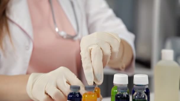 Médico femenino recogiendo un medicamento en una jeringa y lo prepara para la inyección — Vídeo de stock