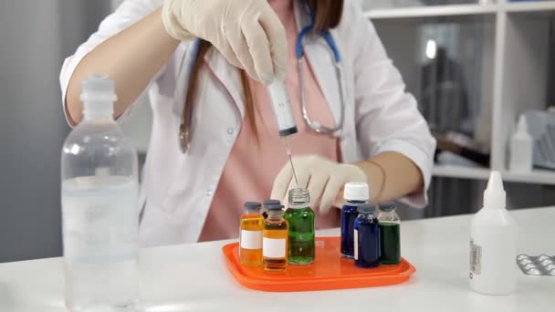 Médico femenino recogiendo un medicamento en una jeringa y lo prepara para la inyección — Vídeos de Stock