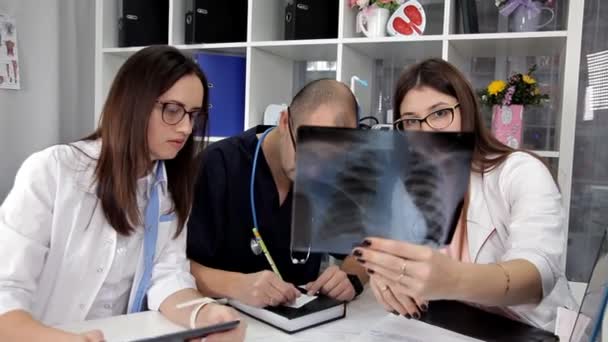 Het team van artsen onderzoekt de resultaten van het analyseren van de patiënten in het kantoor — Stockvideo