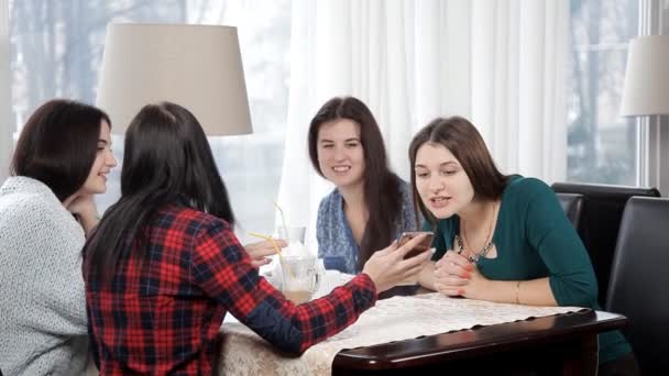 Quattro ragazze bevono un latte o un caffè in un caffè ridendo e parlando. addio al nubilato con caffè. pausa caffè — Video Stock