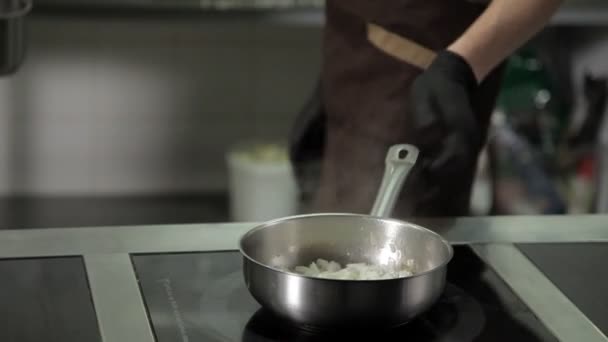 Повар разогревает сковороду на кухне ресторана — стоковое видео
