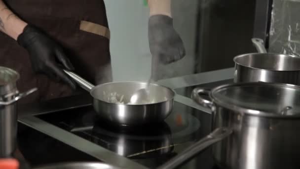 Повар разогревает сковороду на кухне ресторана — стоковое видео