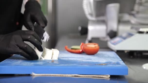 Cook with gloves on preparing a salad in the kitchen of the restaurant — Stock Video