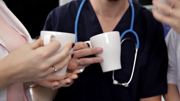 Jonge artsen drinken koffie tijdens de lunch en het bespreken van hun werk, de behandeling van de patiënt — Stockvideo