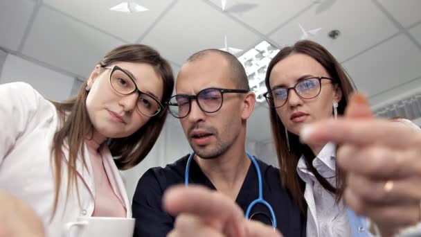 Los médicos jóvenes toman café en el almuerzo y discuten su trabajo, el tratamiento del paciente — Vídeo de stock