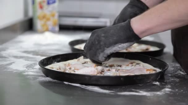 Закрывай. Готовить в перчатках в приготовлении пиццы на кухне ресторана — стоковое видео