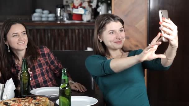 Birkaç kız pizza yemek ve restoran şişelerde üzerinden bira içmek. Kahkaha konuşmak ve kutlamak — Stok video
