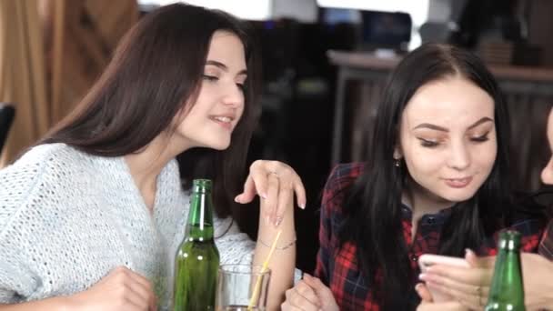 Varias chicas comen pizza y beben cerveza de botellas en el restaurante. Habla ríete y celebra — Vídeo de stock