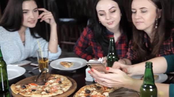 Parecchie ragazze mangiano pizza e bevono birra dalle bottiglie del ristorante. Parlare ridere e festeggiare — Video Stock