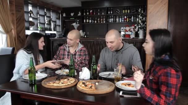 Un gruppo di giovani beve birra e mangia pizza in un ristorante — Video Stock
