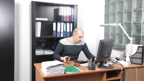 Um homem que trabalha no escritório no local de trabalho. muito trabalho — Vídeo de Stock