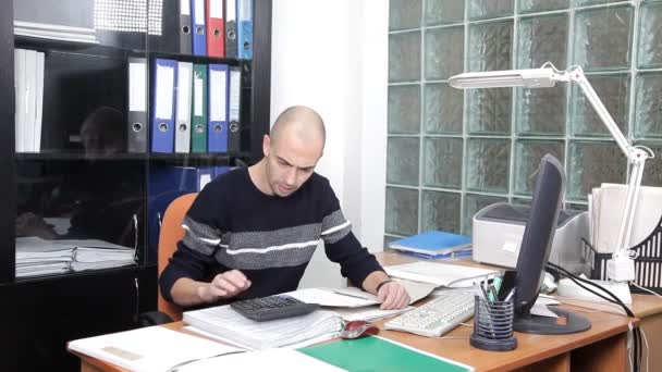 En man som arbetar på kontoret i arbetsplatsen. för mycket arbete — Stockvideo
