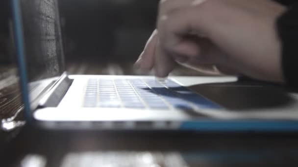 Um escritor escreve um livro romance em um laptop contra uma parede de tijolo — Vídeo de Stock