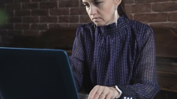 Ein Schriftsteller schreibt einen Buchroman auf einem Laptop gegen eine Ziegelwand — Stockvideo