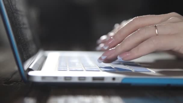 Um escritor escreve um livro romance em um laptop contra uma parede de tijolo — Vídeo de Stock