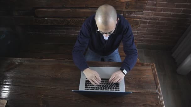 Pisarz pisze powieść książki na laptopa przed mur z cegły — Wideo stockowe