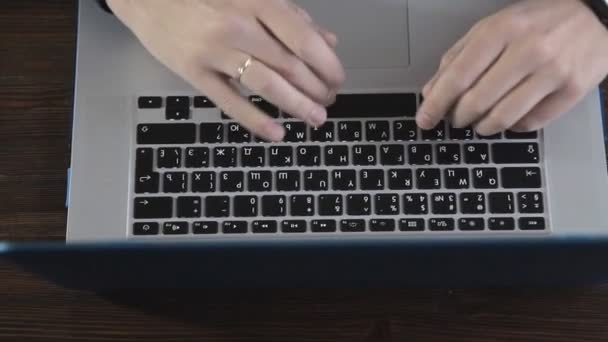 Uno scrittore scrive un romanzo su un computer portatile contro un muro di mattoni — Video Stock