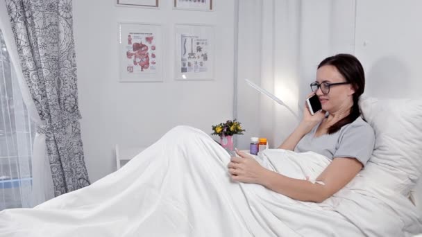 Vrouwelijke patiënt met behulp van mobiele telefoon In ziekenhuisbed — Stockvideo