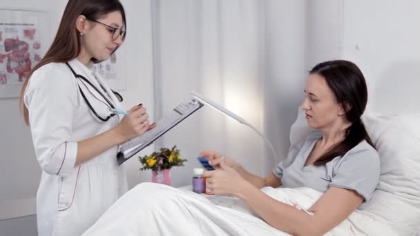 Bir doktor hasta koğuşunda sağlık ve tedavi onun durumuyla ilgili notlar yapıyor — Stok video