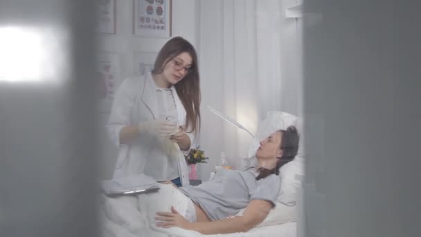 Läkaren kommunicerar med sjuka patienten, stöder henne och talar om behandling — Stockvideo