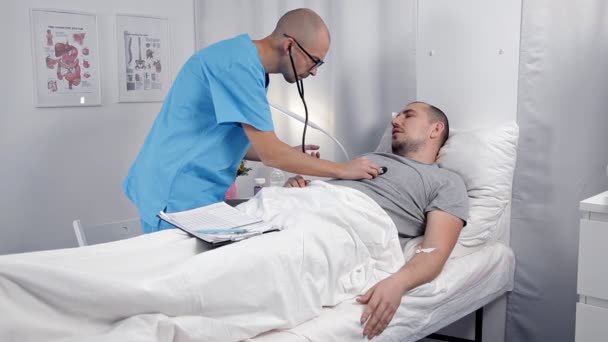 Il medico di sesso maschile ascolta i pazienti battito cardiaco nel reparto medico. Medicina e concetto di assistenza sanitaria — Video Stock