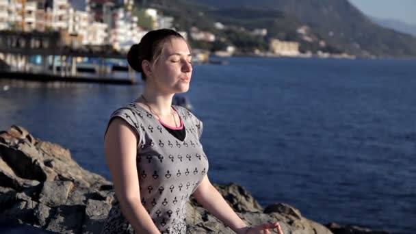 Ung frisk kvinna utövar yoga på stranden i soluppgången, fördelarna med naturliga miljöer för fysisk — Stockvideo
