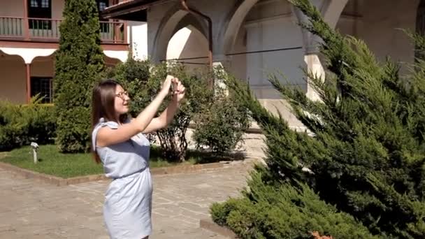 Bir kız bir yabancı şehrin turistik yerleri yürür. Gezi. Bahçe — Stok video
