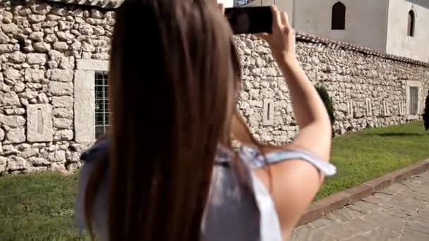 Una chica camina alrededor de los lugares de interés de una ciudad desconocida. Excursión. Jardín — Vídeos de Stock