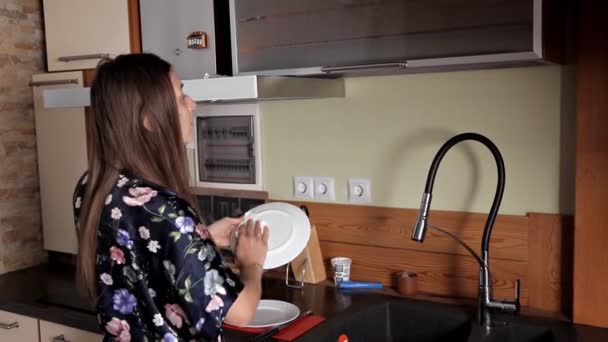 Jovem menina lavar pratos na cozinha — Vídeo de Stock