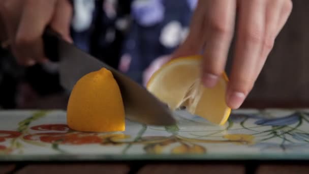 Cutting lemon on a board for preparing fresh and aromatic fruit juice — Stock Video