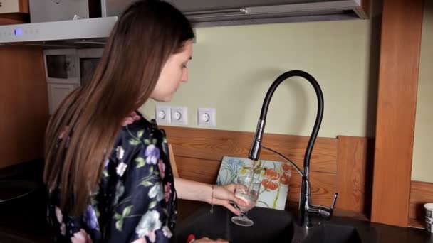 Mädchen bekommt ein Glas Wasser aus dem Wasserhahn in der Spüle und trinkt — Stockvideo