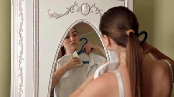 Ein junges Mädchen geht morgens zur Arbeit, zieht sich an und frisiert sich die Haare — Stockvideo