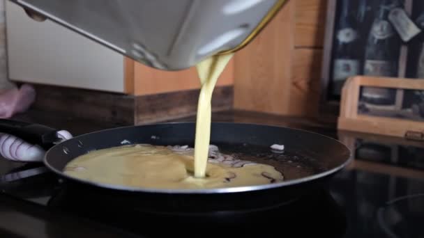 Het meisje kookt een omelet in de pan — Stockvideo